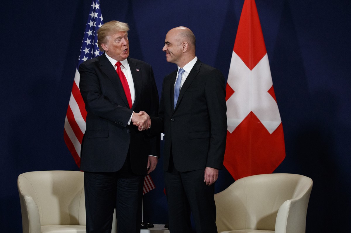 U.S. President Donald Trump shakes, left, hands with Swiss President Alain Berset during their meeting at the World Economic Forum, Friday, Jan. 26, 2018, in Davos, Switzerland. (AP Photo/Evan Vucci)