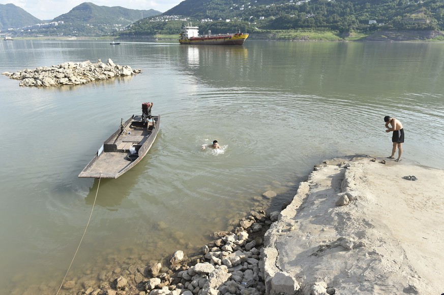 Residents cool off along the Yangtze River in Yunyang county in southwest China's Chongqing Municipality Tuesday, Aug. 16, 2022. Unusually high temperatures and a prolonged drought are affecting ...