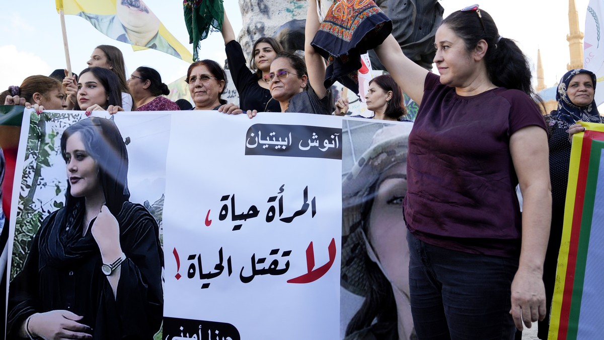FILE - Kurdish women activists hold headscarfs and a portrait of Iranian woman Mahsa Amini, with Arabic that reads, "The woman is life, don't kill the life," during a protest against he ...