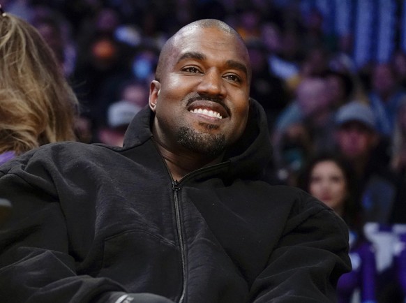 FILE - Kanye West watches the first half of an NBA basketball game between the Washington Wizards and the Los Angeles Lakers in Los Angeles on March 11, 2022.  Former President Donald Trump dined…