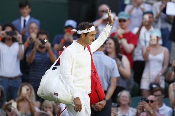 epa06857684 Defending champion Roger Federer arrives on Centre Court for his first round match against Dusan Lajovic of Serbia during the Wimbledon Championships at the All England Lawn Tennis Club, i ...