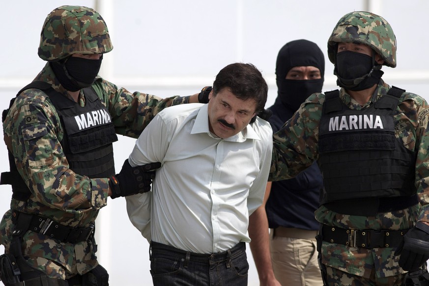 FILE - In this Feb. 22, 2014 file photo, Joaquin &quot;El Chapo&quot; Guzman, center, is escorted to a helicopter in handcuffs by Mexican navy marines at a hanger in Mexico City, after he was captured ...