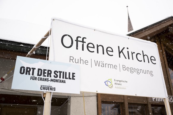 Signs reading Ort der Stille für Crans-Montana and Offene Kirche  Ruhe, Wärme, Begegnung are seen in front of the Kapelle im Boden a few hours before a minute of silence in memory of the victims, ...