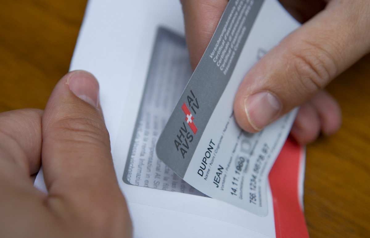 A man takes a prototype of the new insurance certificate of the AHV-IV (AHV: Federal old-age and bereaved people insurance/IV: Disabled people insurance) with the name of the insured party, the date o ...