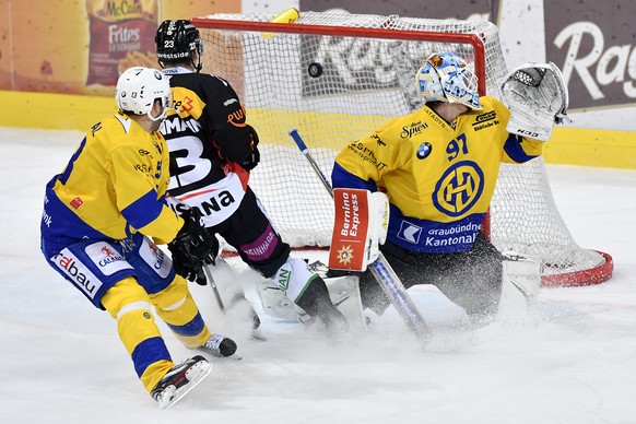 Berns Simon Bodenmann, Mitte, trifft gegen Davos&#039; Goalie Gilles Senn, rechts, und Robert Kousal zum 2:1 in der Verlaengerung im Eishockey National League A Spiel zwischen dem SC Bern und dem HC D ...