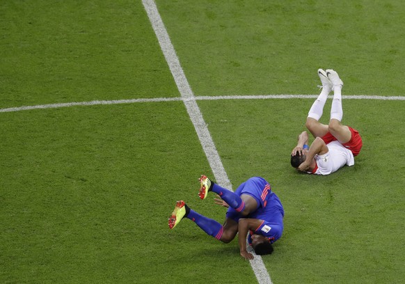 Colombia&#039;s Yerry Mina, left, and Poland&#039;s Robert Lewandowski fall to the ground after colliding during the group H match between Poland and Colombia at the 2018 soccer World Cup at the Kazan ...