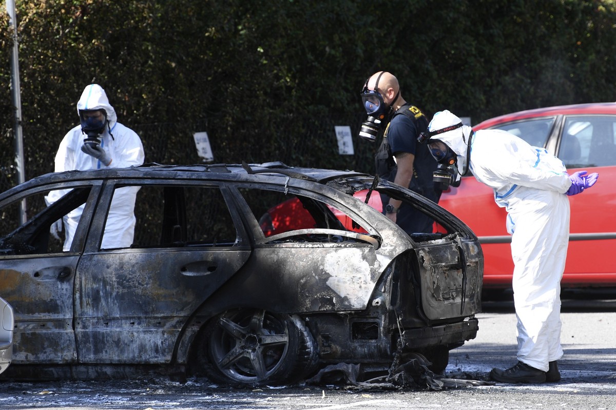 epa07795236 Police and criminal technical investigators examine a burnt out car near the crime scene where a woman was shot dead in Ribersborg, Malmo, 26 August 2019. EPA/Johan Nilsson SWEDEN OUT