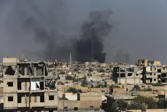 Black smoke rises from Raqqa city where U.S.-backed Syrian Democratic Forces fighters battle against Islamic State militants, in Raqqa, northeast Syria, Thursday, July 27, 2017. U.S.-backed Syrian fig ...