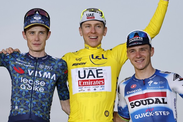 epa11490726 Yellow Jersey and Tour de France overall winner Slovenian rider Tadej Pogacar (C) of UAE Team Emirates, second placed Danish rider Jonas Vingegaard (L) of Team Visma Lease a Bike and Belgi ...