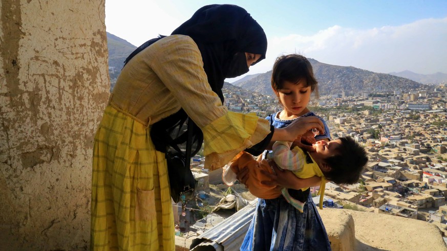 epa10194408 A health worker administers a polio vaccine to a child during a polio vaccination campaign in Kabul, Afghanistan, 19 September 2022. A four-day anti-polio vaccination campaign targeting 9. ...