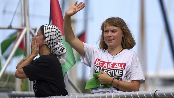 Swedish climate activist Greta Thunberg waves from a boat taking part in a civilian flotilla bound for Gaza, aiming to break the Israeli blockade and deliver humanitarian aid, in Barcelona, Spain, Sun ...