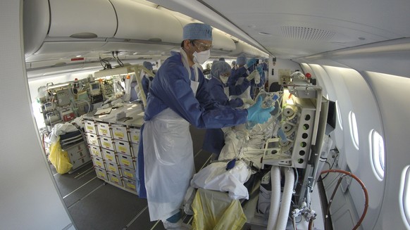 This GoPro image provided Saturday March 28, 2020 by the French Army shows doctors taking care of evacuated patients infected with the Covid-19 disease, aboard a military plane from Mulhouse, eastern  ...