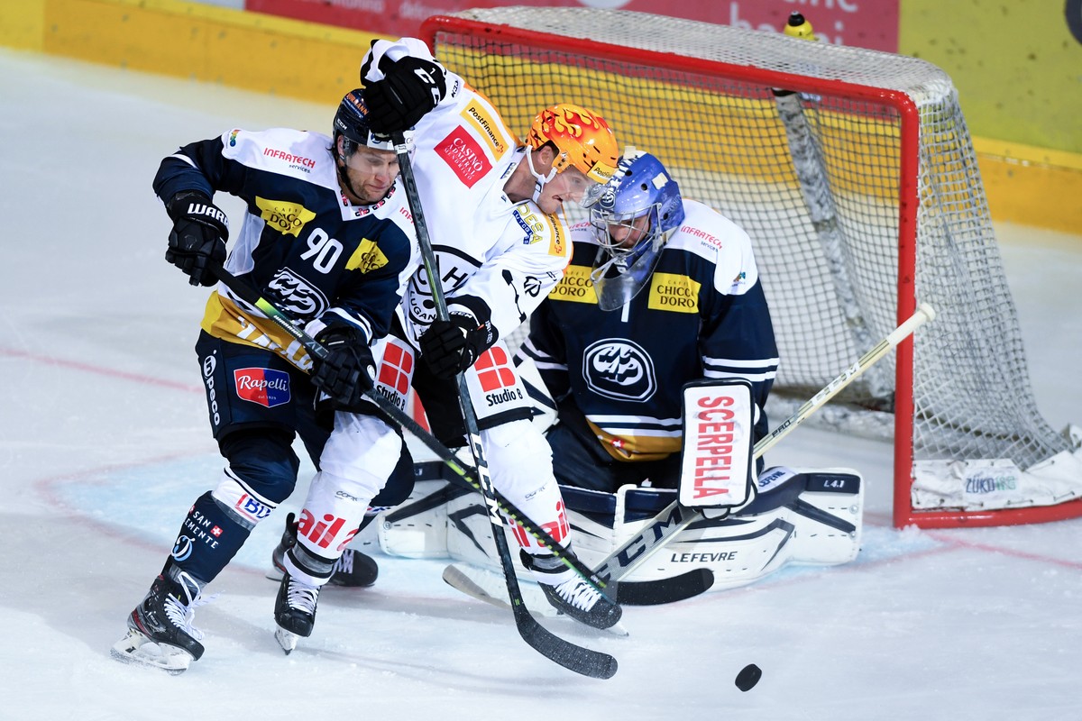 From left Ambri's player Jannik Fischer, Lugano's player Daniel Carr and Ambri's goalkeeper Benjamin Conz, during the preliminary round game of National League A (NLA) Swiss Championshi ...