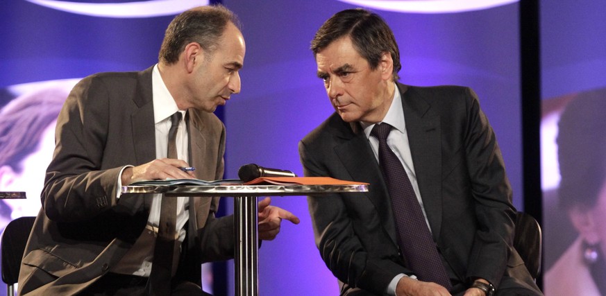 French UMP (Union for a Popular Movement) political party head Jean-Francois Cope (L) speaks with former French prime minister Francois Fillon (R) at a political rally in Strasbourg, March 5, 2014. Th ...