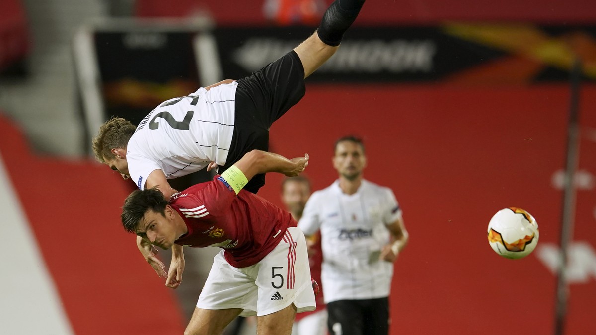 LASK's Marko Raguz is airborne as he battles for the ball with Manchester United's Harry Maguire during the Europa League round of 16 second leg soccer match between Manchester United and LA ...
