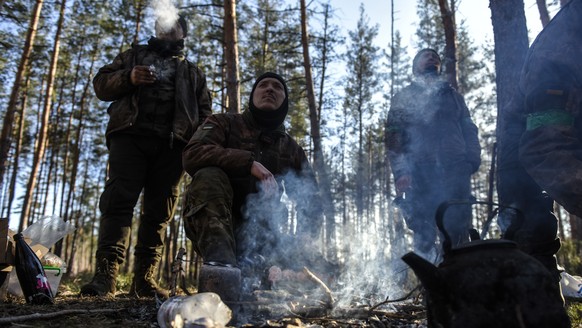 epa10434322 Ukrainian servicemen brew tea at a position in a forest in Donetsk region, Eastern Ukraine, January 27, 2023. Russian troops on February 24, 2022, troops entered Ukrainian territory, starting with ...