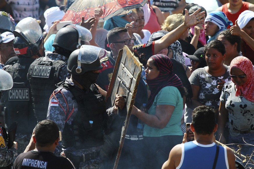 Relatives argue with police as they protest outside the Anisio Jobim Prison Complex where a riot erupted among inmates in the northern state of Amazonas, Brazil, Sunday, May 26, 2019. At least eight p ...