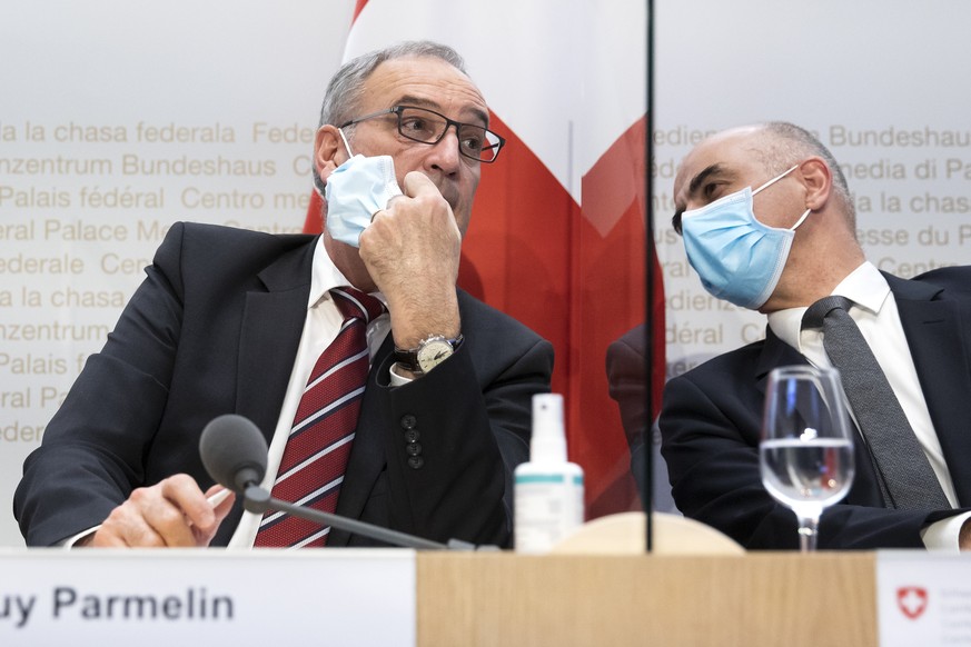 Bundesrat Alain Berset, rechts, diskutiert mit Bundespraesident Guy Parmelin, waehrend einer Medienkonferenz des Bundesrates zur aktuellen Lage im Zusammenhang mit dem Coronavirus, am Mittwoch, 13. Ja ...