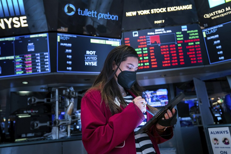 FILE - In this Friday, Jan. 15, 2021, file photo provided by the New York Stock Exchange, trader Ashley Lara works on the floor, in New York. CEOs have begun telling shareholders how much profit their ...