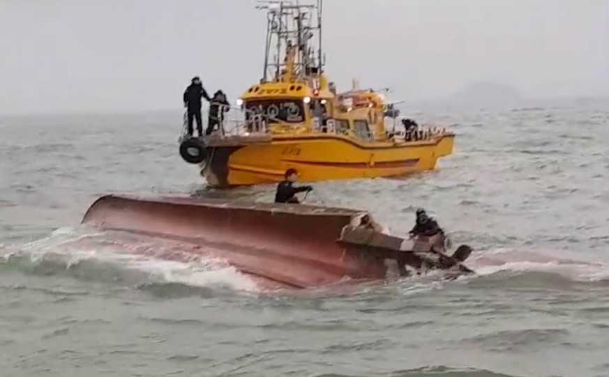 epa06364677 A handout photo made available by the Korea Coast Guard (KCG) shows rescuers conducting a search operation for missing people from a capsized 9.77-ton chartered fishing boat in a collision ...