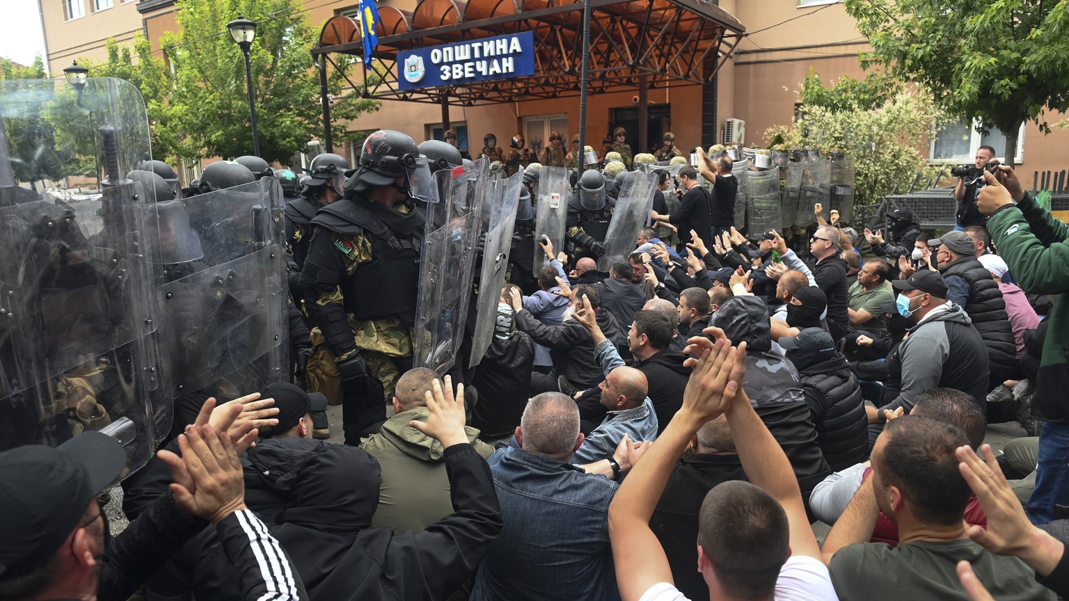 epa10662175 Ethnic Serbs sit on the street in front of the cordon of soldiers of NATO-led international peacekeeping Kosovo Force (KFOR) in front of the building of the municipality in Zvecan, Kosovo, ...