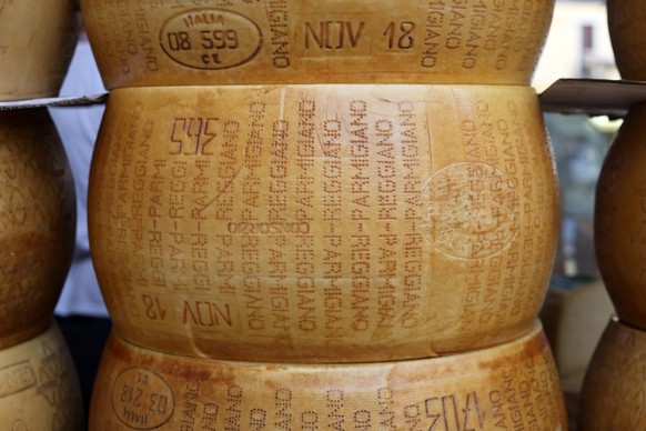 Whole wheels of Parmigiano Reggiano cheese, Cremona, Italy - September 7, 2022: Whole wheels of Parmigiano Reggiano cheese sold at a street stall during the farmers market in Cremona, Lombardy, Italy, ...