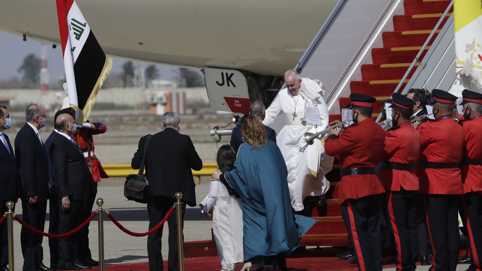 Pope Francis walks down the steps of an airplane as he arrives at Baghdad international airport, Iraq, Friday, March 5, 2021. Pope Francis heads to Iraq to urge the country&#039;s dwindling number of  ...