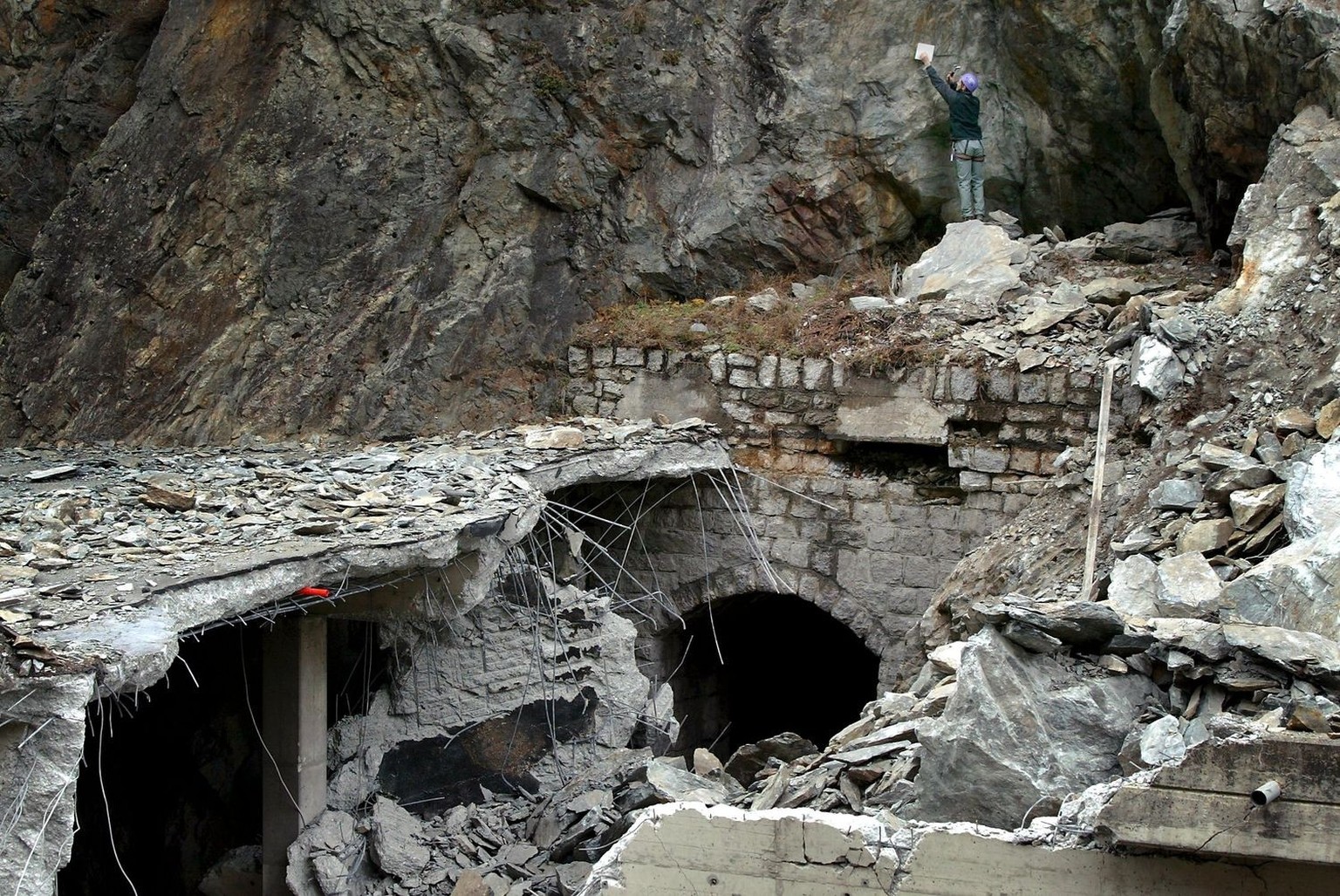 Un geologue, en haut a droite, s&#039;occupe a verifier la falaise, ce lundi 1 decembre 2003, apres qu&#039;un pan de rocher d&#039;environ 600m3 s&#039;est detache, detruisant samedi une galerie rout ...