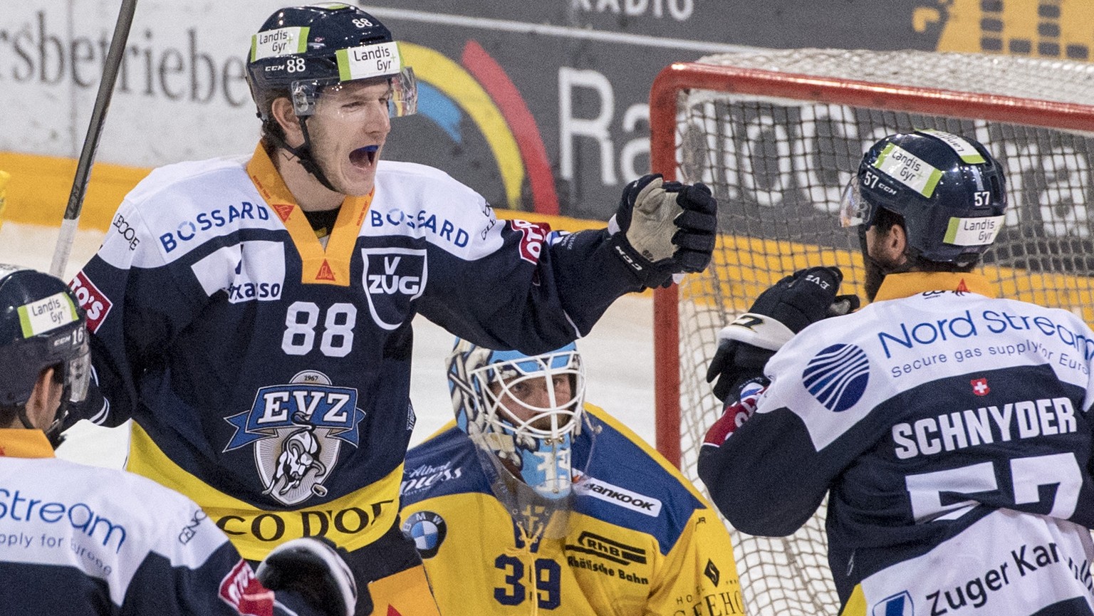 Die Zuger mit Reto Suri, Sven Senteler und Fabian Schnyder, vorne, feiern das 1:0 vor Torhueter Anders Lindbaeck, mitte, von Davos beim Eishockey Meisterschaftsspiel in der Qualifikation der National  ...