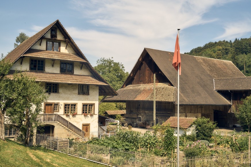 A home with its vegetable garden next to the barn. Rauszeit Wundersame Orte der Schweiz Spezielle Orte