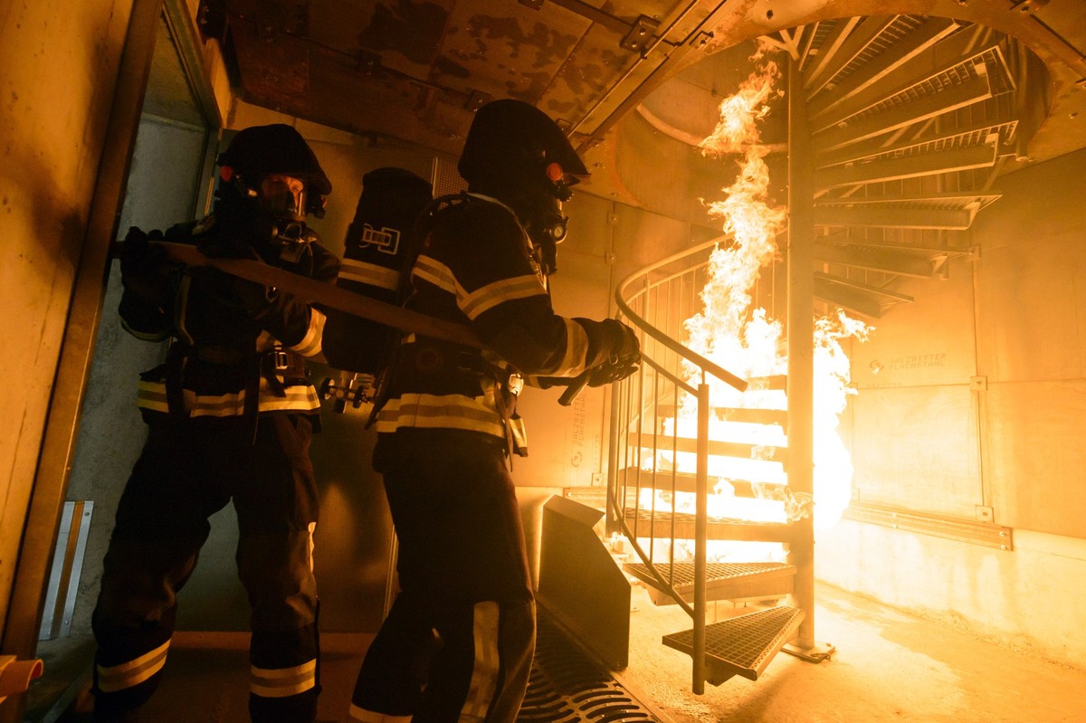 Un pompier lutte contre les flammes sous un escalier dans le nouveau simulateur incendie du centre de formation de la Rama ce vendredi 9 mai 2014 a Cugy, Montheron, Vaud. Le nouveau simulateur incendi ...