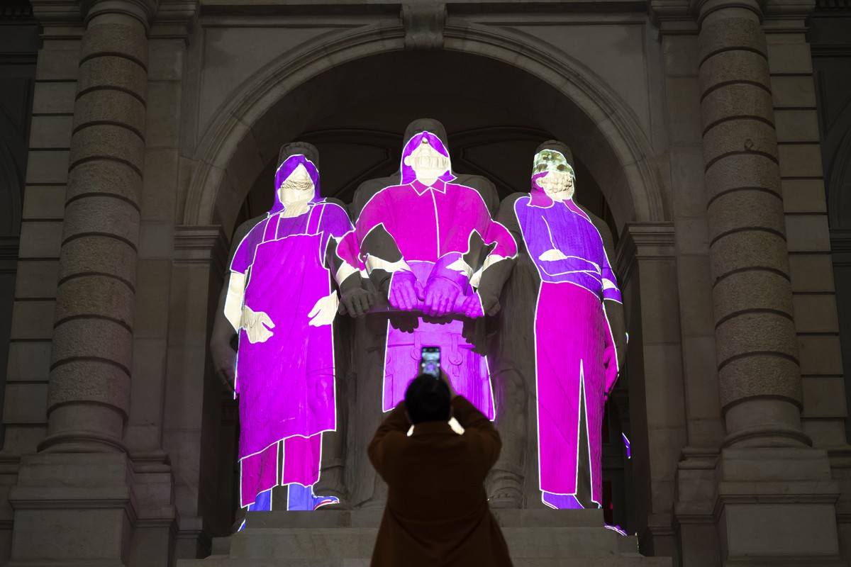 KEYPIX - Eine Teilnehmerin fotografiert den Drei Eidgenossen, auf die Frauenfiguren in der Farbe pink projeziert werden, bei einer Veranstaltung zum Internationalen Tag der Frau, am Freitag, 7. Maerz  ...
