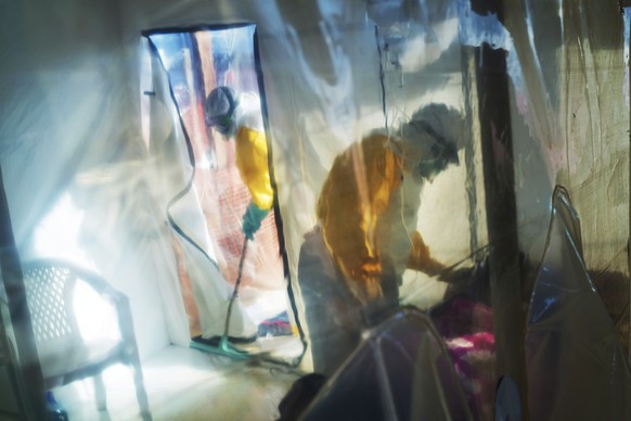 FILE - In this Saturday, July 13, 2019 file photo, health workers wearing protective suits tend to an Ebola victim kept in an isolation tent in Beni, Democratic Republic of Congo. On Wednesday, Oct. 14, 2020, the U.S. Food and Drug Administration said it has approved Inmazeb, a drug made by Regeneron, for treating Ebola in both adults and children. (AP Photo/Jerome Delay)