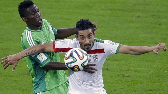 FILE - In this June 16, 2014 file photo, Iran&#039;s Reza Ghoochannejhad, right, challenges for the ball with Nigeria&#039;s Kunle Odunlami l during the group F World Cup soccer match between Iran and ...