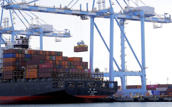 FILE - In this Nov. 4, 2019, file photo cargo cranes are used to take containers off of a Yang Ming Marine Transport Corporation boat at the Port of Tacoma in Tacoma, Wash. The U.S. trade deficit surg ...