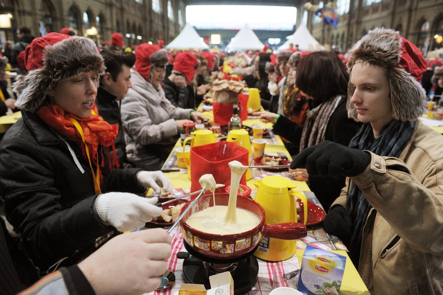 Gegen 800 Personen stellen am Samstag, 12. Januar 2013, in der Halle des Hauptbahnhofes Zuerich einen neuen Weltrekord im Fondue-Essen auf. (KEYSTONE/Steffen Schmidt)