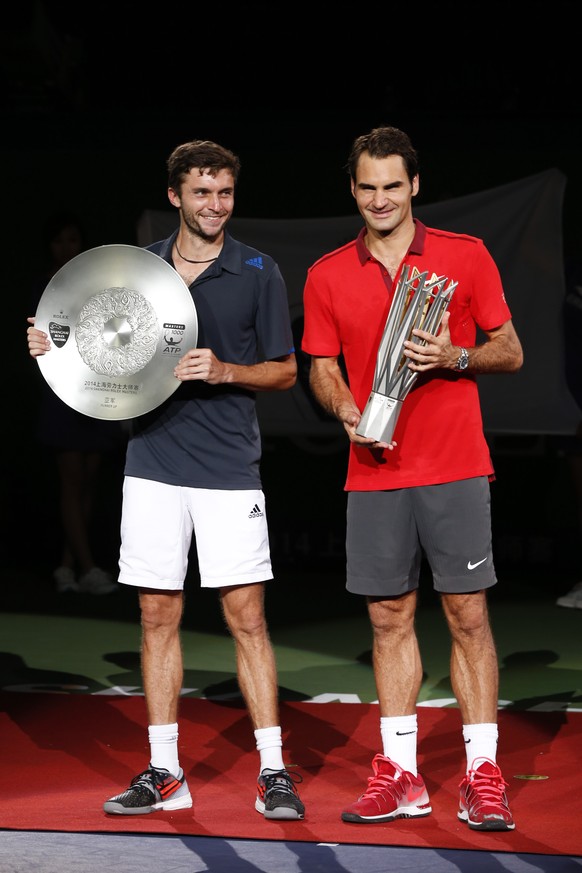 Roger Federer of Switzerland, right, and Gilles Simon of France pose with trophy during the awards ceremony after Federer won the men&#039;s singles final at the Shanghai Masters Tennis Tournament in  ...