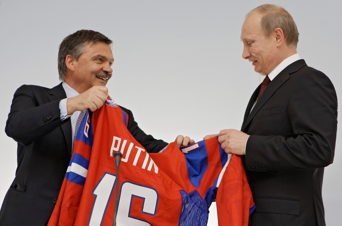 President of the International Ice Hockey Federation Rene Fasel, left, gives Russian Prime Minister Vladimir Putin a hockey jersey with the inscription "Putin 16" after a joint news conferen ...