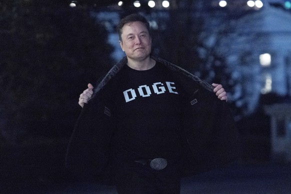 Elon Musk flashes his t-shirt that reads &quot;DOGE&quot; to the media as he walks on South Lawn of the White House, in Washington, Sunday, March 9, 2025. (AP Photo/Jose Luis Magana)
Elon Musk