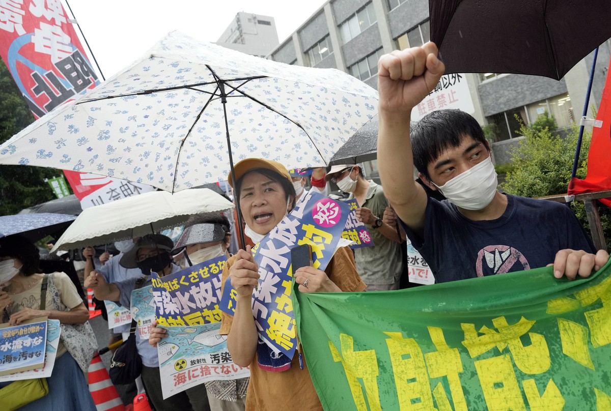 epa10812909 Protesters shout slogans and hold banners reading 'Don't discharge contaminated water into the sea!' during a rally in front of the Prime Minister's official residence  ...