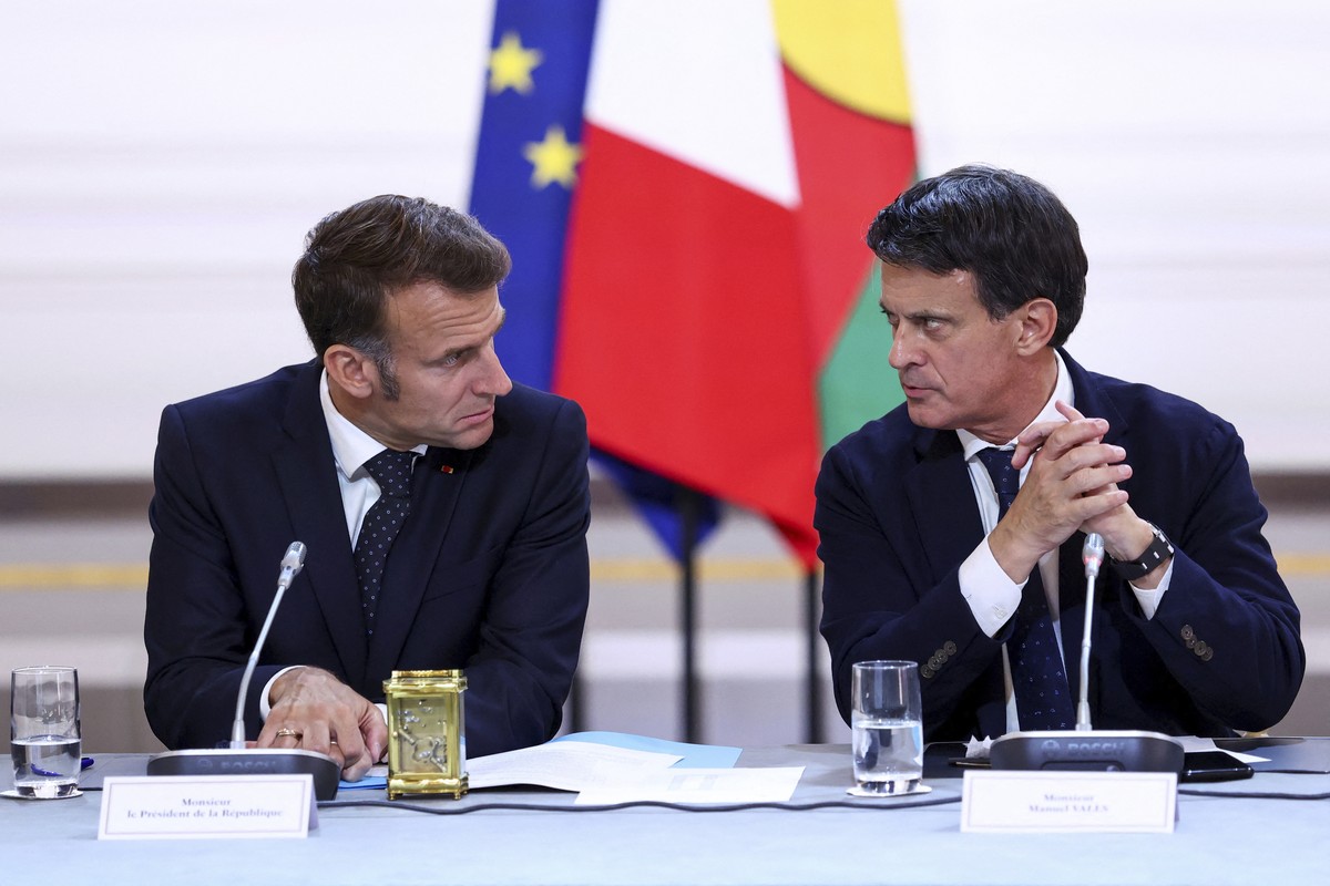 President Emmanuel Macron, left, and Minister for Overseas Territories Manuel Valls attend a meeting with New Caledonia's elected officials and state representatives for an agreement aimed at gra ...