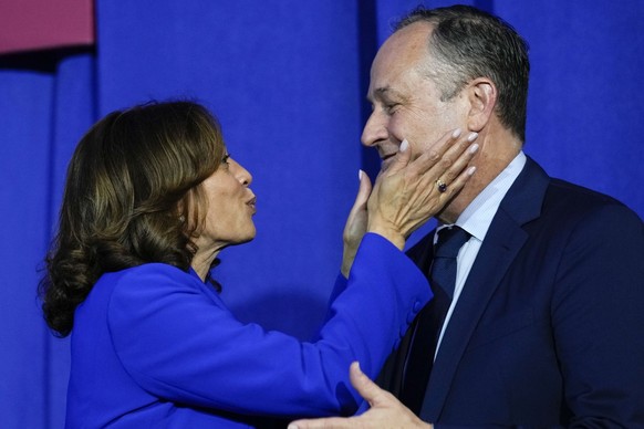 Second gentleman Doug Emhoff, left, and Democratic presidential nominee Vice President Kamala Harris listen during speeches at the Democratic National Convention, Monday, Aug. 19, 2024, in Chicago. (G ...