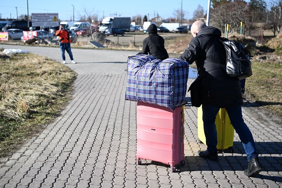 epa09781467 People walk near the Polish-Ukrainian border crossing in Medyka, Poland 24 February 2022. The Polish Ministry of Interior and Administration informed they have reception points for refugee ...