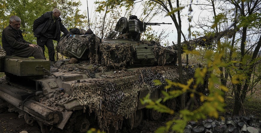 Ukrainian servicemen stand on Ukrainian Soviet-made T-64 tank, in Bakhmut, Ukraine, Sunday, Oct. 2, 2022. (AP Photo/Inna Varenytsia)