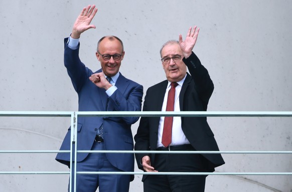 epaselect epa12972956 German Chancellor Friedrich Merz (L) and Swiss President Guy Parmelin wave as they talk on the balcony of the Chancellery in Berlin, Germany, 19 May 2026. EPA/HANNIBAL HANSCHKE