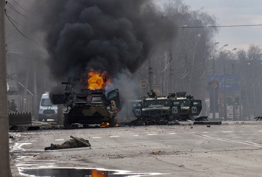 FILE - An armored personnel carrier burns amid damaged and abandoned Russian light utility vehicles after fighting in Kharkiv, Ukraine, Sunday, Feb. 27, 2022. The city authorities said that Ukrainian ...