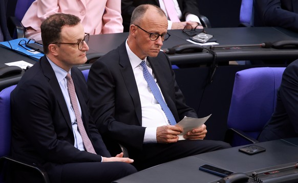epa12077794 CDU faction leader Jens Spahn (L) and designated German Chancellor Friedrich Merz prior to the second round of voting at the Bundestag in Berlin, prior to the second round of voting at the ...