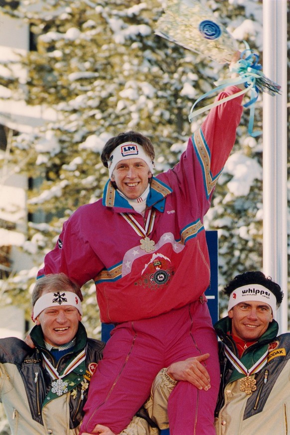DOWNHILL MEDALIST: Downhill Gold medalist Hansjoerg Tauscher, of West Germany, rides the shoulders Switzerlands second place finisher Peter Mueller (left) and Karl Alpinger at the World Alpine Champio ...