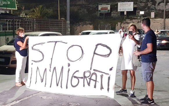 epa08635042 Residents protest against the continuing landings of migrants on the island of Lampedusa, Italy, 30 August 2020. About 450 migrants aboard an old fishing boat disembarked overnight between ...