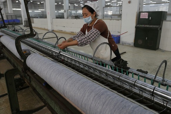 A worker disentangles wool yarn at a spinning machine at a factory owned by Hong Kong&#039;s Novetex Textiles Limited in Zhuhai City, Guangdong Province, China December 13, 2016. Picture taken Decembe ...